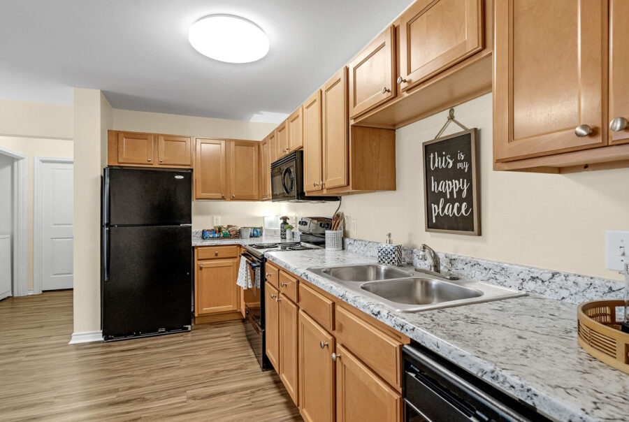 Fully equipped apartment kitchen with granite-style countertops and wood cabinetry at The Overlook Nacogdoches TX