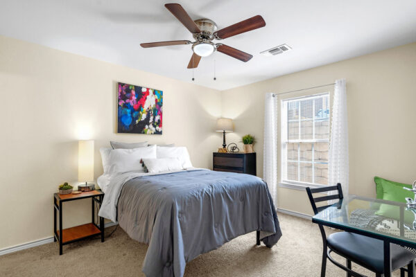 Furnished bedroom with full-size bed and study desk in a student apartment at The Overlook Nacogdoches TX