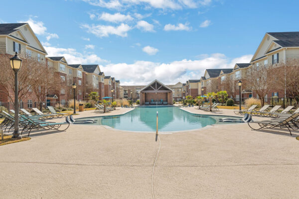 View of resort-style pool with lounge chairs and pavilion at The Overlook student apartments Nacogdoches TX