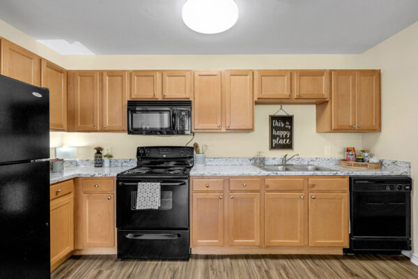 Fully equipped kitchen with wood cabinetry and granite countertops in a student apartment at The Overlook Nacogdoches